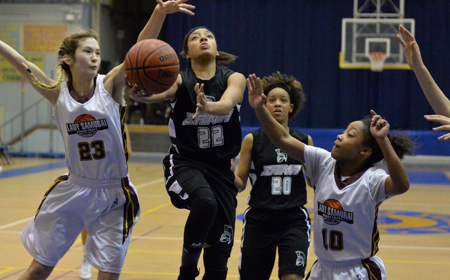 Zama's Ti'Ara Carroll shoots between Perry's Naomi Ziola and Devon Shuman during Friday's semifinal game in the DODDS Japan basketball tournament. The Trojans won 39-22 and face Yokota for the title on Saturday.