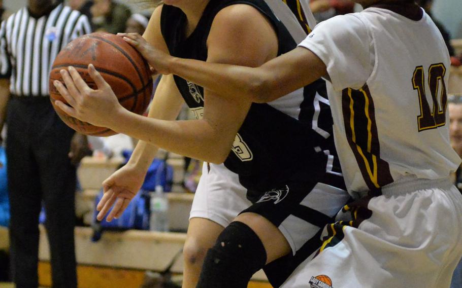 Zama's Ally Chiarenza wriggles toward the basket between Perry's Naomi Ziola and Devon Shuman during Friday's semifinal game in the DODDS Japan basketball tournament. The Trojans won 39-22 and will meet Yokota for the title on Saturday.