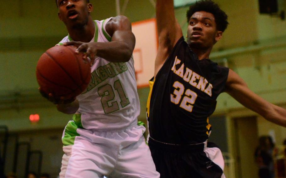 Kubasaki's Isaiah Johnson tries to control the ball against Kadena's Jeremiah Steed during Friday's boys basketball game, won by the Dragons 67-49.  Kubasaki completed a regular-season sweep of the Panthers with the win.