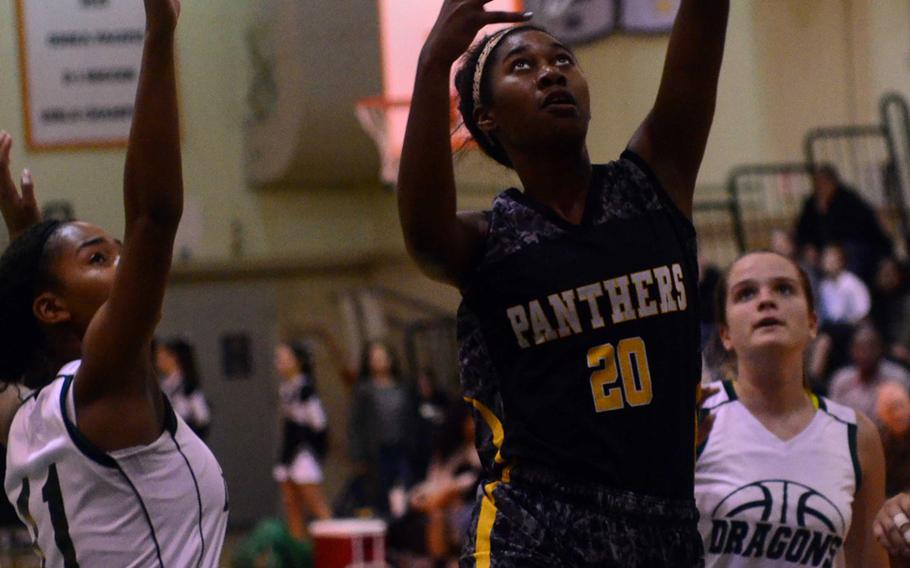 Kadena's Brenda Gulley drives against Kubasaki's Josie Daffin and Chloe' Stevens during Friday's girls basketball game, won by the Panthers 44-31. Kadena completed a regular-season sweep of the Dragons with the win.