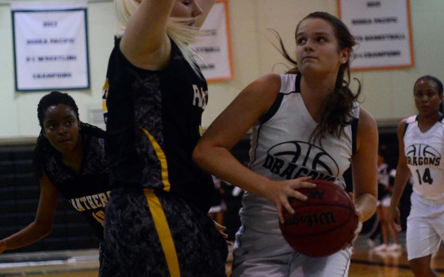 Kubasaki's Chloe' Stevens drives to the basket against Kadena's Laura Erp during Friday's girls basketball game, won by the Panthers 44-31. Kadena completed a regular-season sweep of the Dragons with the win.
