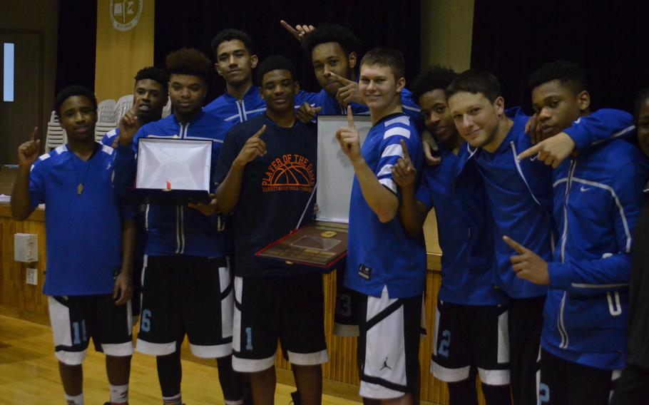 Seoul American players celebrate with their championship hardware after Saturday's 54-50 win over Humphreys in the Korea Blue Division tournament final.