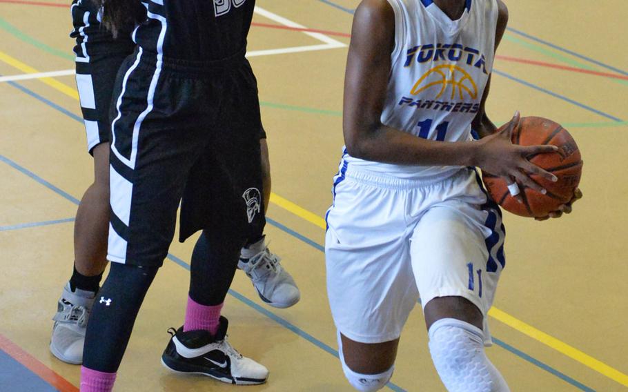 Yokota's Kaliah Henderson drives to the basket past Zama's Aika Ramsey during Saturday's DODDS Japan girls final, won by the Panthers 52-39.
