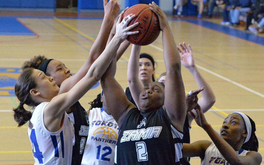 Zama's Destiny Thomas fights for a rebound between Yokota foes and Trojans teammates during Saturday's DODDS Japan girls final, won by the Panthers 52-39.