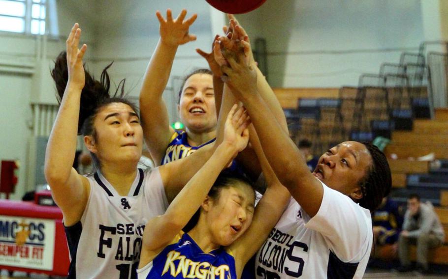 CAJ's Mieko Yamamoto is caught at the bottom of the pile while battling Renee Thompson and Latisha Dolford or Seoul American and her teammate Michelle van den Berg for a rebound during CAJ's 27-23 Far East Tournament round robin loss to the Falcons Feb. 15, 2016 at Camp Foster in Okinawa, Japan.  