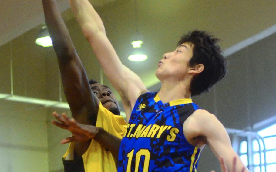 Lane Woody of St. Mary's redirects Kadena's Jahron Mitchell shot in St. Mary's 66-63 Far East Tournament round robin overtime win over the Panthers Feb. 15, 2016 at Camp Foster in Okinawa, Japan.  