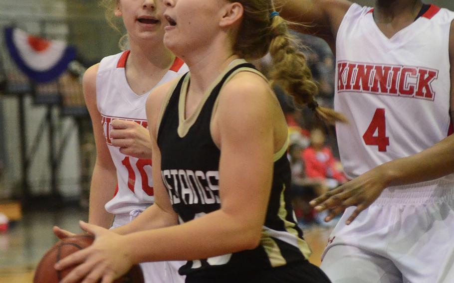 ASIJ's Allie Rogers splits the Kinnick defense of Kailee Rucker and Qua Jones during ASIJ's 19-15 Far East Tournament round robin win over the Devils Feb. 15, 2016 at Camp Foster in Okinawa, Japan.  
