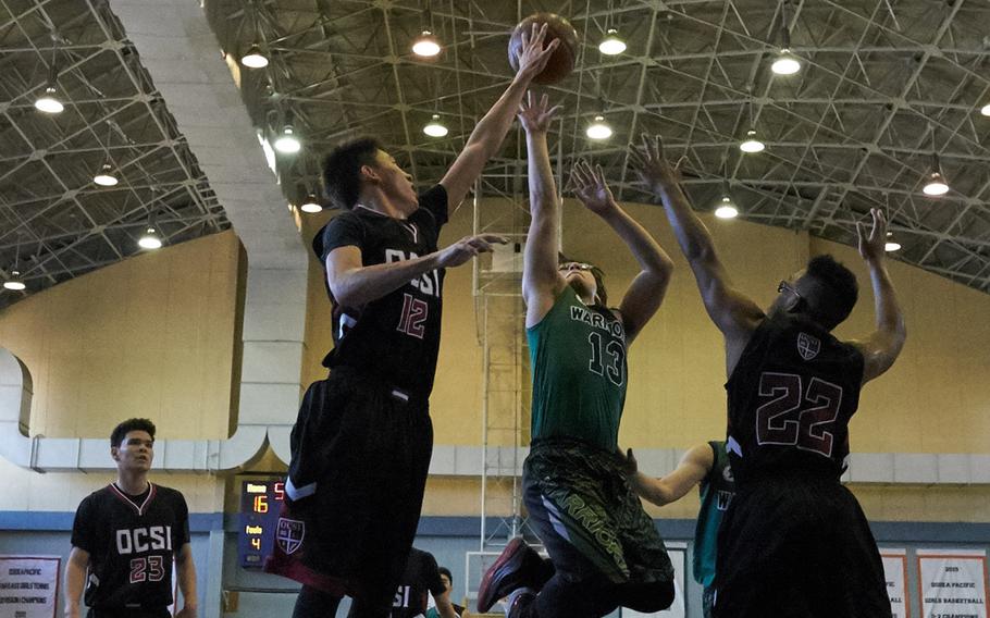 Okinawa Christian's Shawn Monroe blocks a  shot by Daegu's Kenneth Musselwhite during the Far East Tournament Boys Division II pool play at Yokota Air Base, Japan, on Tuesday, Feb. 16, 2016.  