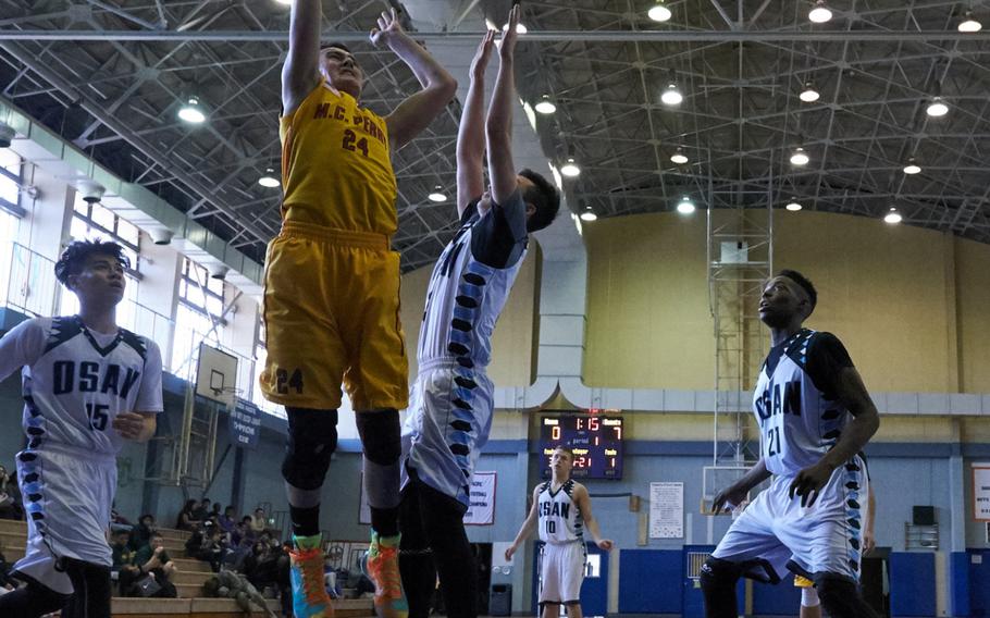 M.C. Perry's Garrett Macias powers a short jump shot over the Osan defense during the Far East Tournament Boys Division II pool play at Yokota Air Base, Japan, on Tuesday, Feb. 16, 2016. 