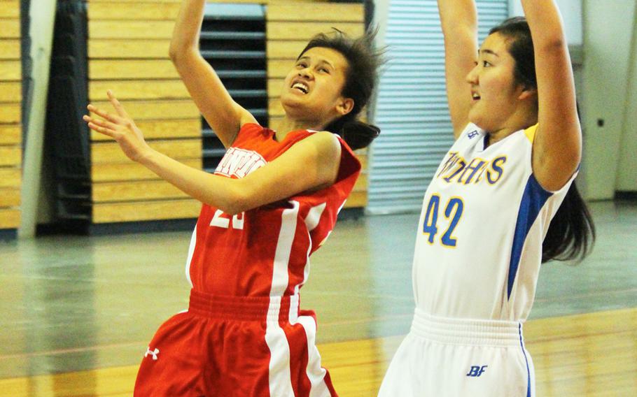 Kinnick's Jeanne Rosario shoots past CAJ's Jessie Suzuki during the Far East Tournament Girls Division I pool play at Camp Foster in Okinawa, Japan on Tuesday, Feb. 16, 2016.  