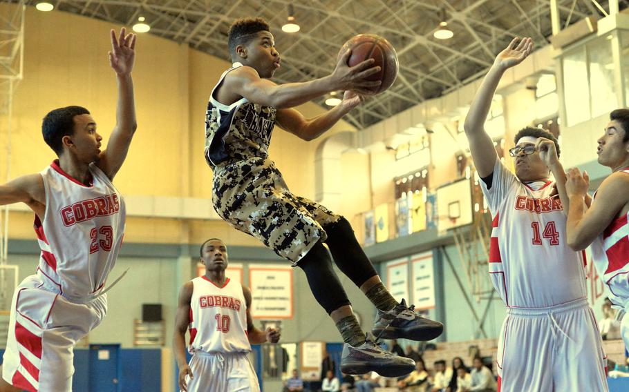 Humphreys' Bashr Edmonds splits King's Seth Hudson (left) and John Coleman during the Far East Tournament Boys Division II pool play at Yokota Air Base, Japan on Tuesday, Feb. 16, 2016.  