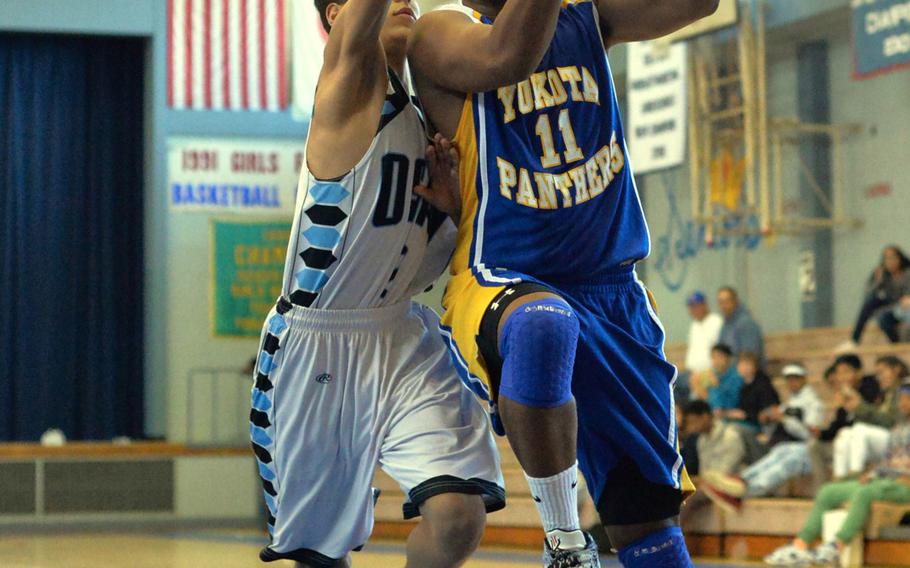 Yokota's Marcus Henagan drives past Osan's Miguel Villareal during the Far East Tournament Boys Division II pool play at Yokota Air Base, Japan on Tuesday, Feb. 16, 2016.  