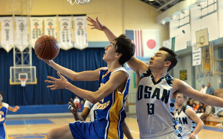 Yokota's Hunter Cort finds space past Osan's Matthew Burbee during the Far East Tournament Boys Division II pool play at Yokota Air Base, Japan on Tuesday, Feb. 16, 2016.  