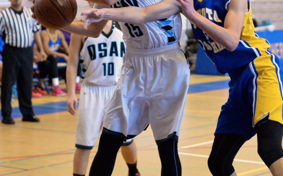 Osan's Sung DeAngelo and Yokota's Renyck Robertson battle for a loose ball during the Far East Tournament Boys Division II pool play at Yokota Air Base, Japan on Tuesday, Feb. 16, 2016.  