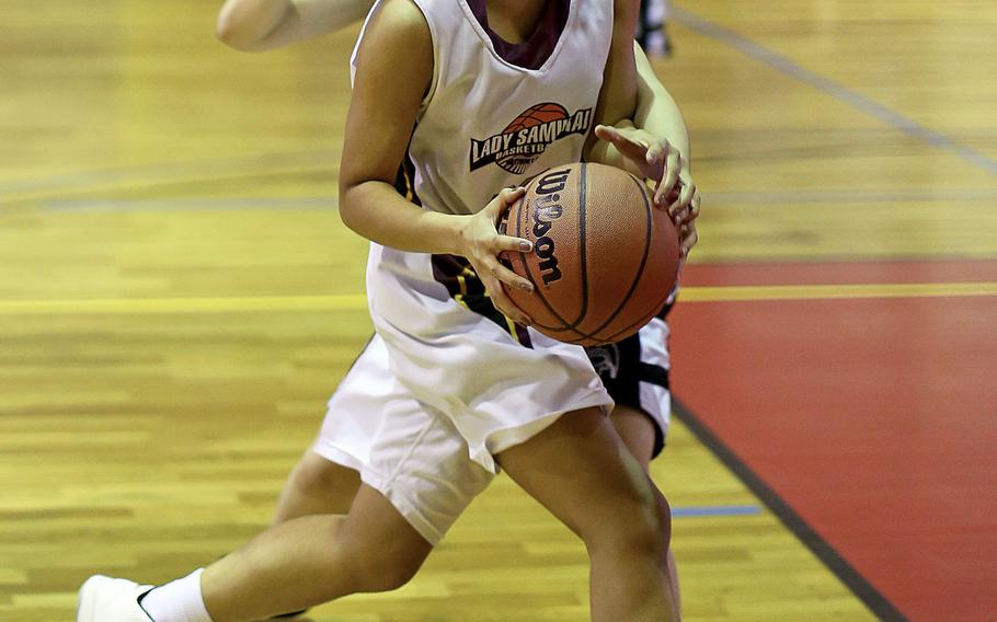 M.C. Perry's Sakura Felming drives through the Zama defense during the Far East Tournament Girls Division II pool play at Marine Corps Air Station Iwakuni, Japan on Tuesday, Feb. 16, 2016.  