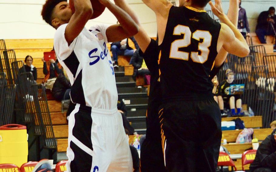 Seoul American's Donnavan Scott has his shot blocked by American School in Japan's Ian McGuire during the Far East Tournament Boys Division I pool play at Camp Foster in Okinawa, Japan on Tuesday, Feb. 16, 2016.  
