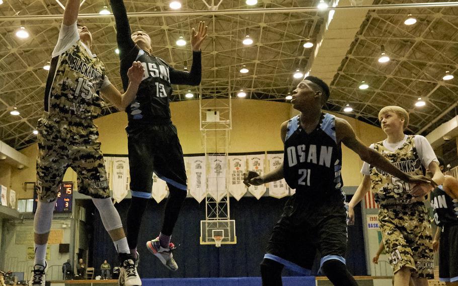 Osan's Mathew Burbee blocks a shot attempt by Humphreys' Omar Lopez  during the Far East Boys Division II Tournament on Wednesday, Feb. 17, 2016 at Yokota Air Base, Japan.