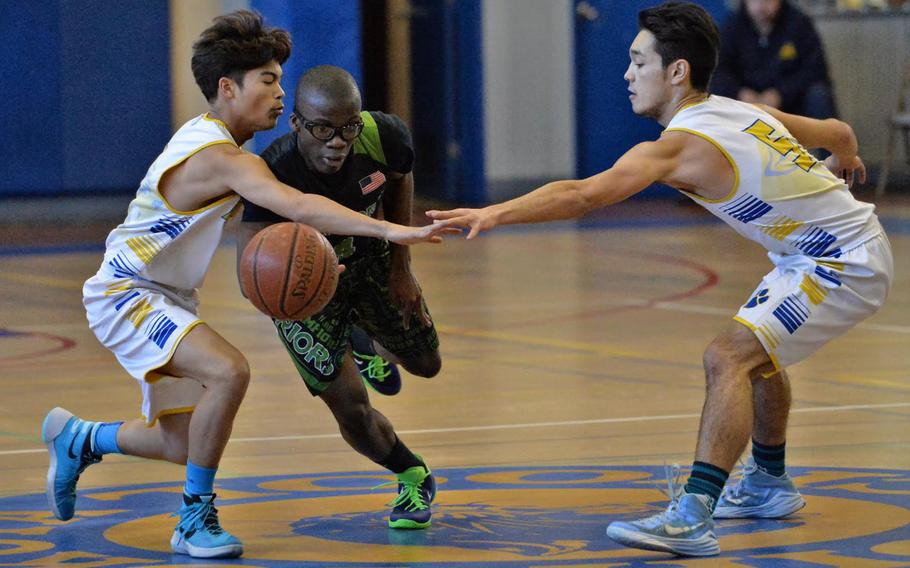 Daegu's Simeon Lynch draws a foul from Yokota's Marlon Speighner, left, and Shota Sprunger during the Far East Boys Division II Tournament on Wednesday, Feb. 17, 2016 at Yokota Air Base, Japan.