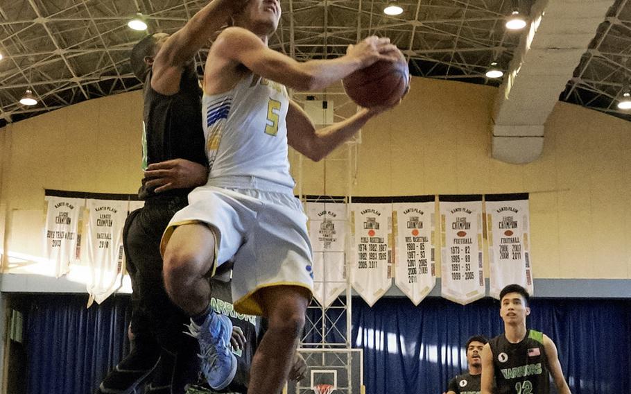 Yokota's Shota Sprunger attempts to finish a fast break as Daegu's Bishop Fields defends in the Far East Boys Division II Tournament on Wednesday, Feb. 17, 2016 at Yokota Air Base, Japan. 
