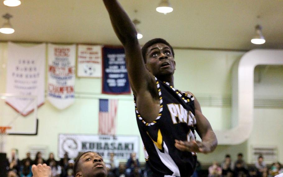 Kadena's Isaiah Richardson goes up for a basket as Kubasaki's Isaiah Johnson watches in the Dragons' 59-32 victory.