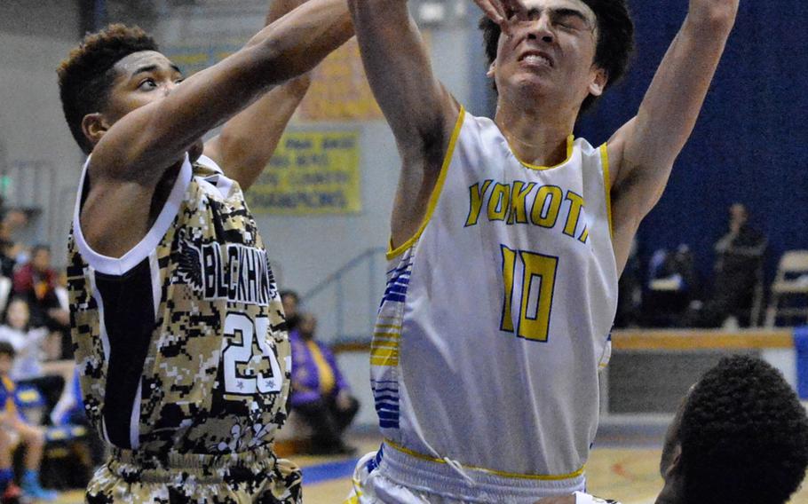 Humphreys' Bashr Edmonds pokes Yokota's Hunter Cort in the eye while trying to grab the ball as teammate Malik Dampier watches.