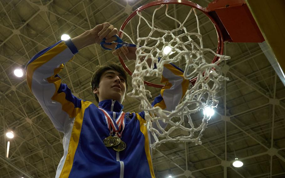 Tournament MVP Hunter Cort of Yokota cuts down the net following the Far East Tournament Boys Division II championship game Feb. 18, 2016 at Yokota Air Base, Japan. Yokota defeated Humphreys 67-51 to repeat as champions. 