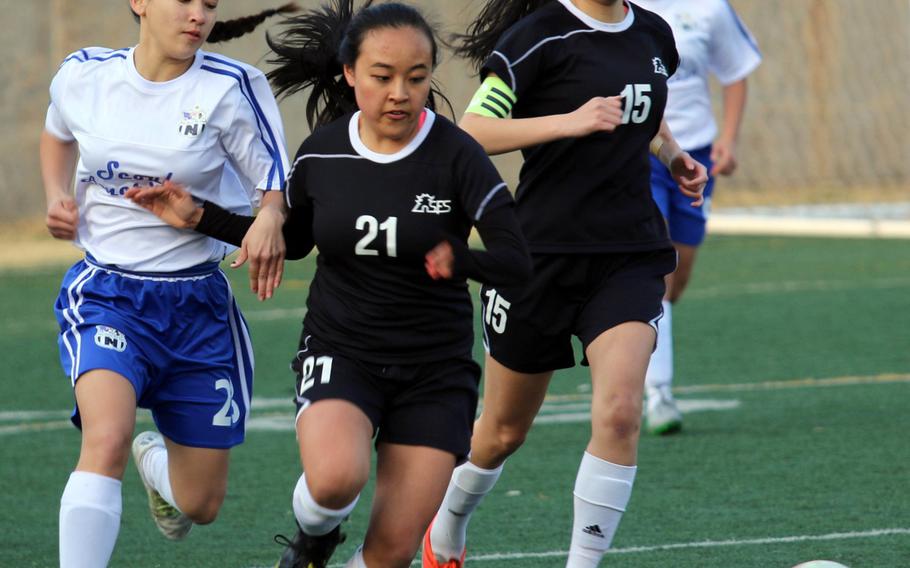 Seoul American's Ashley Clifton and Seoul Foreign's Megan Yu and Callie Chang chase the ball during Wednesday's girls soccer match, won by the Crusaders 1-0.