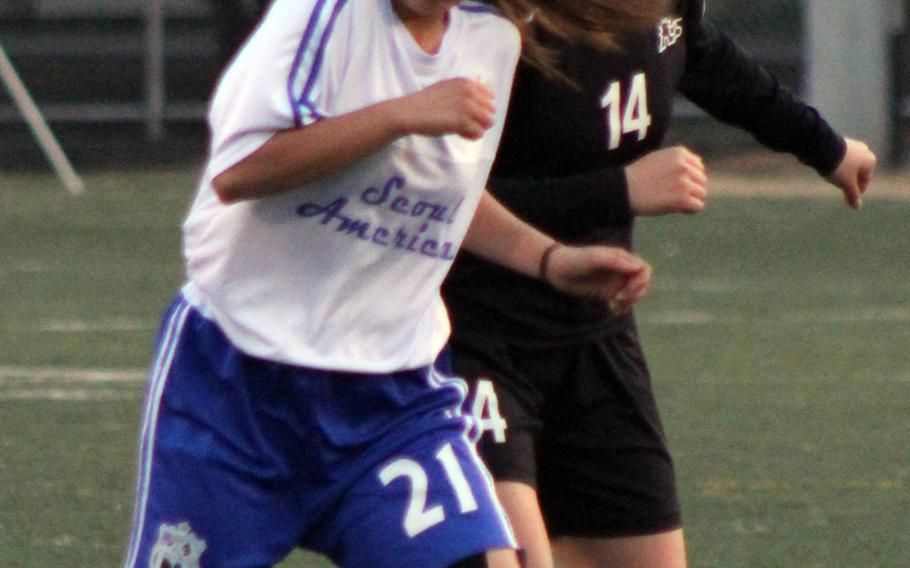 Seoul American's Reyna Harding heads the ball against Seoul Foreign during Wednesday's girls soccer match, won by the Crusaders 1-0.