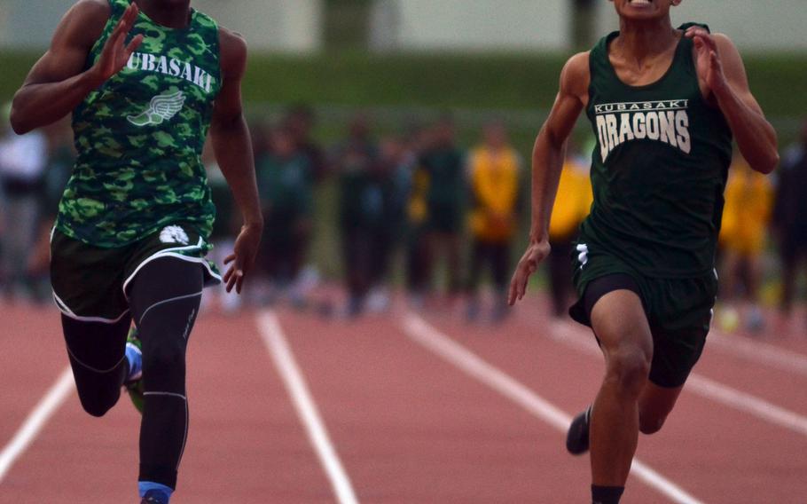 Kubasaki sophomore Mahlik Francis and senior Takao Elliot run side-by-side toward the finish of the 100 in Friday's Okinawa season-opening track and field meet. Francis won in 11.46 seconds.