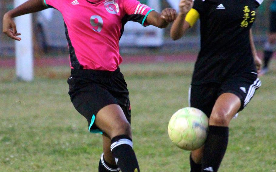 Kubasaki's Da'Zha Loney has her kick blocked by Kadena's Adri Gomez during Thurday's girls soccer match. The Dragons and Panthers battled to a 2-2 draw; Kubasaki still leads the season series 1-0-1.