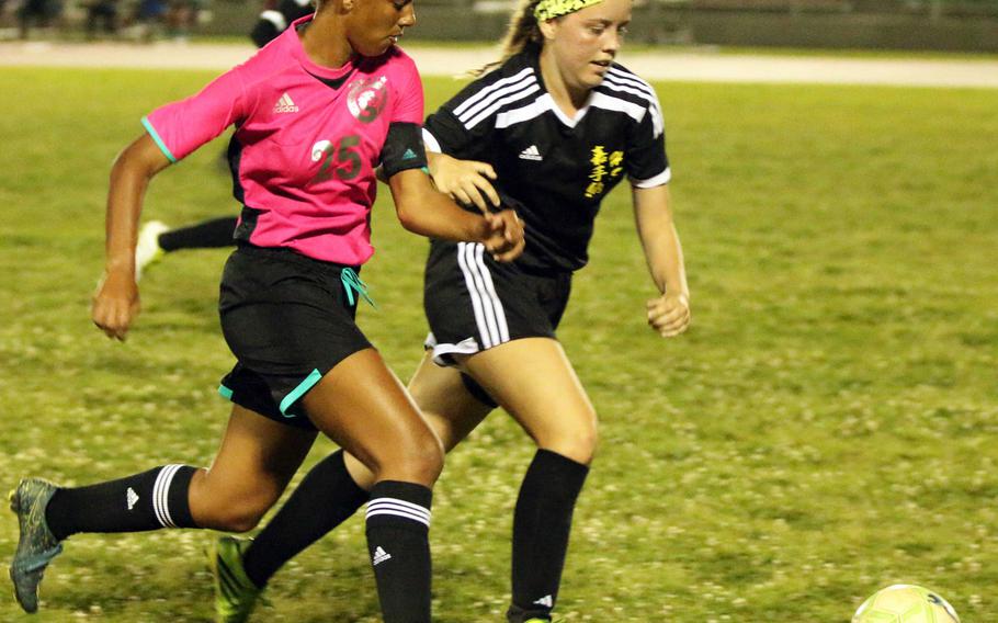 Kubasaki's Myca Ingram and Kadena's Sydne Fletcher chase the ball during Thursday's girls soccer match; the Dragons and Panthers played to a 2-2 draw.