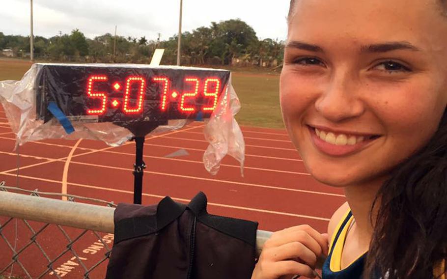 Guam sophomore Emma Sheedy stands beside the clock showing her winning time of 5:07.29, a new island record in the 1,500-meter run. She broke the old mark of 5:11.47 set last season by Alison Bowman of John F. Kennedy High School.