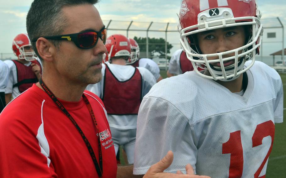 Kinnick coach Dan Joley confers with junior quarterback Kacey Walker.