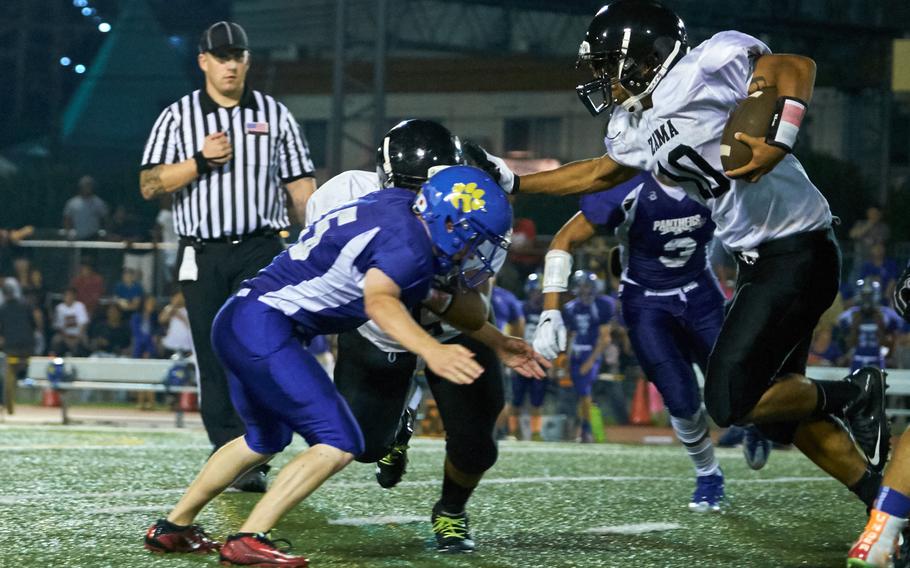 Zama running back Ziaire Johnson stiff arms his way through the Yokota defense in the first game of the 2016 DODEA-Japan season Friday, Sept. 2, 2016, at Yokota Air Base, Japan's Bonk Field. Yokota defeated Zama 22-6.