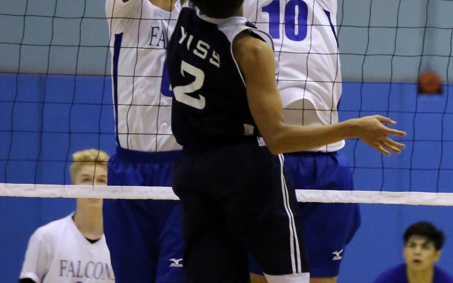 Yongsan's David Kim gets blocked at the net by Seoul American's Sam Broach and Austin Naughton during the Falcons' 11-25, 25-23, 25-19, 25-16 win over the Guardians.