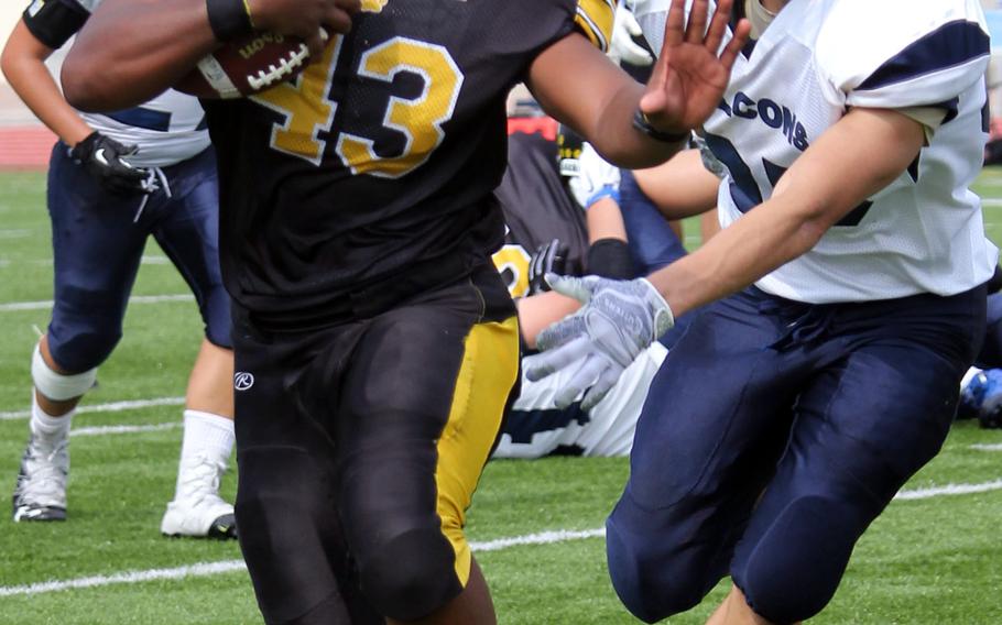 Kadena fullback Uriah Morris tries to stave off the tackle of Seoul American's Brandon Rothe.