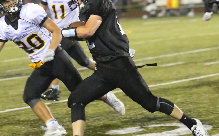 Zama quarterback Sean Canada races to the edge against American School In Japan's Dave Dickson.