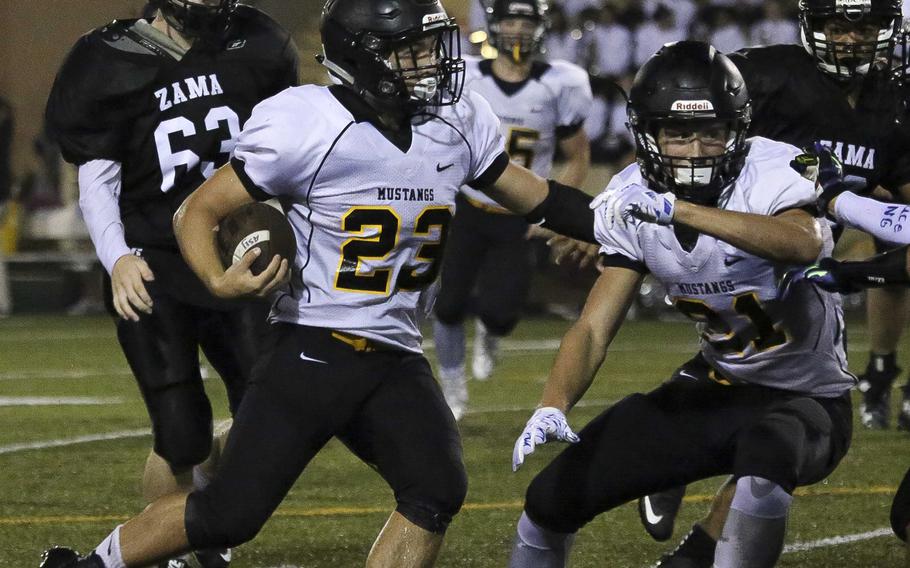 American School In Japan running back Coe Laughlin looks for running room against Zama.