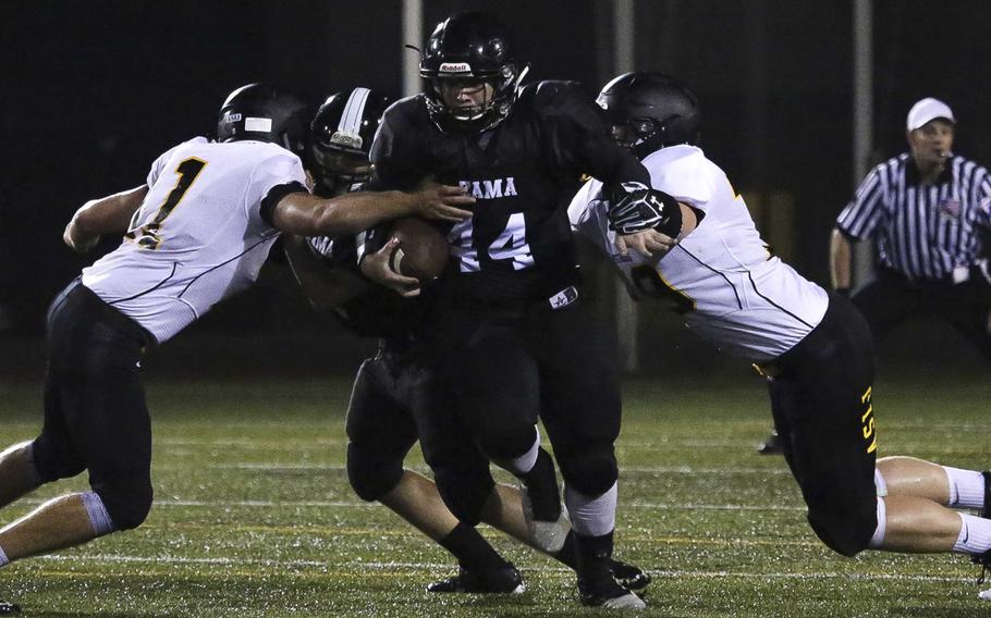 Zama running back Zach Dignan tries to knife his way between two American School In Japan defenders.