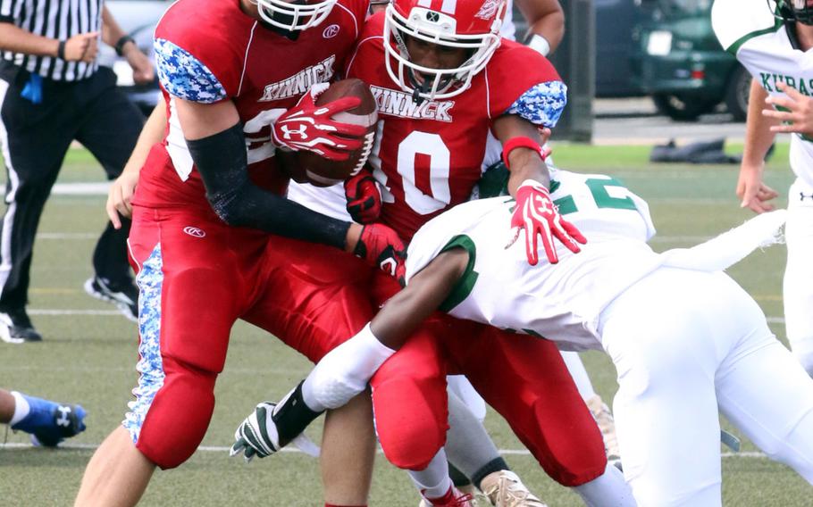 Nile C. Kinnick WR Devoney Stanley gets sandwiched between teammate Josh Brotherton and Kubasaki defender Antonio Mitchell. Kubasaki won 13-6.