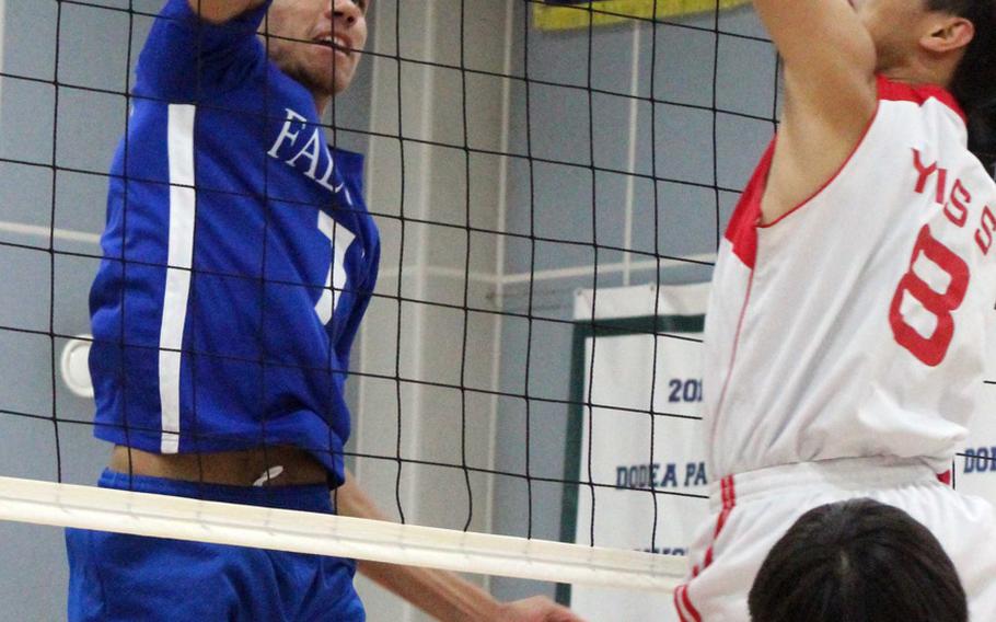 Seoul American's Quentin Metcalf hits the ball against David Kim of Yongsan International School of Seoul during Wednesday's boys volleyball match. The Falcons beat the Guardians 25-22, 25-19, 29-27.