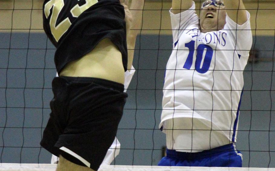 Humphreys' Garrett Taylor tries to blast a spike through the block of Seoul American's Sam Broach. The Falcons won two matches from the Blackhawks on Thursday.