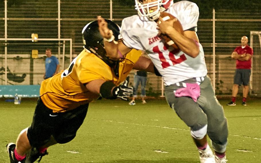 Kinnick quarterback Kacey Walker gets by ASIJ defensive lineman Damon Stone during the Devils game against host ASIJ Saturday, Oct. 1, 2016 in Chofu, Japan. Kinnick defeated ASIJ 29-22.