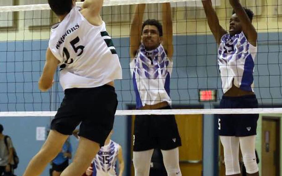 Daegu's Brannin Jackson goes up for a kill against the double block of Seoul American's Quintin Metcalf and Josh Nix during a volleyball match at Falcon Gym Friday, Oct. 7, 2016. The Falcons beat the Warriors in two matches, each in straight sets.

