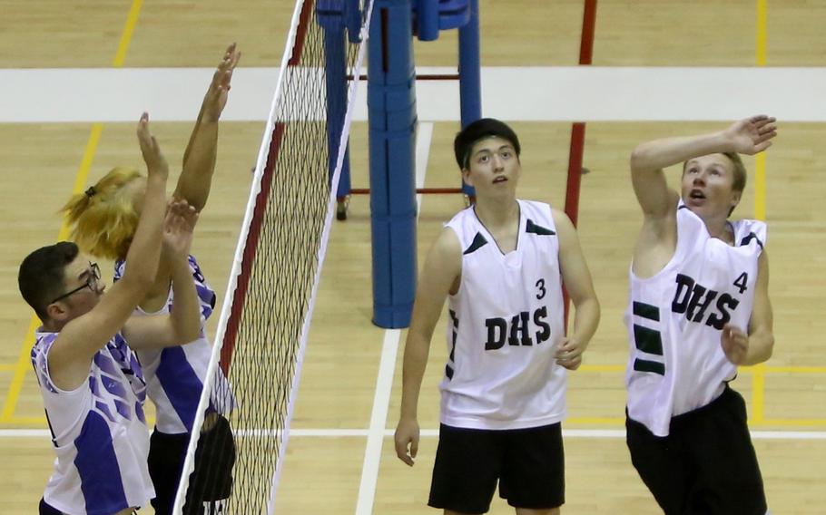Cody Cantrell (4) of Daegu goes up to hit the ball against Seoul American's Sam Broach and Danny Berdine as Warriors teammate Mic Ruff watches during a volleyball match at Falcon Gym Friday, Oct. 7, 2016. 

