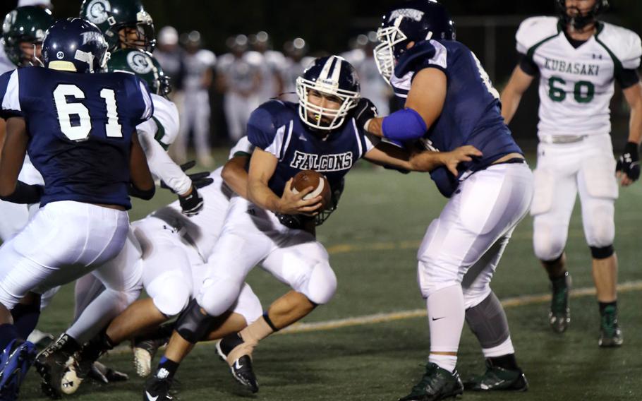 Seoul American quarterback David Messinger knifes his way to daylight through teammates and Kubasaki opponents.