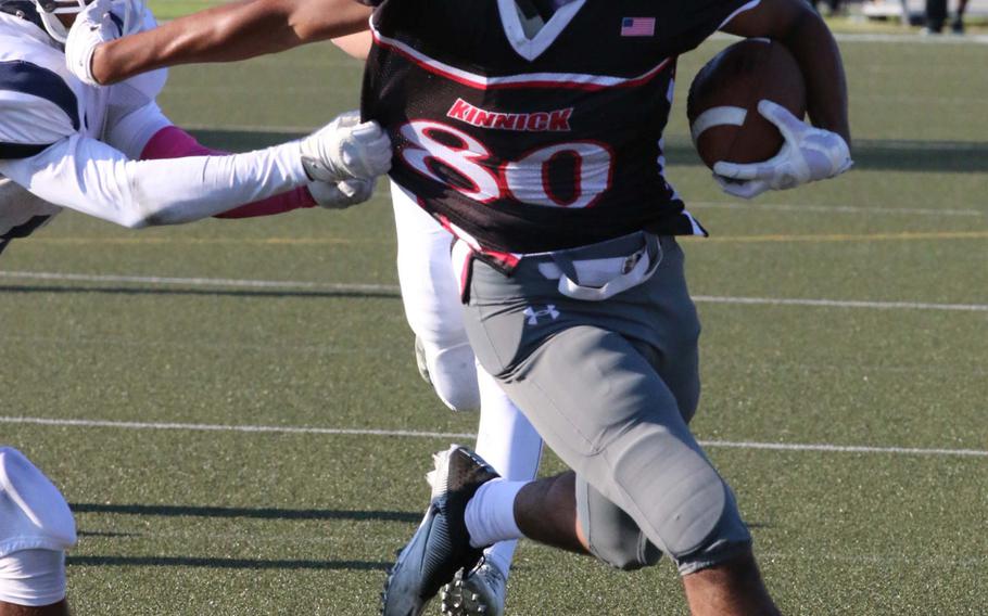 Nile C. Kinnick's Bryan Hunt takes it around left end against Seoul American.