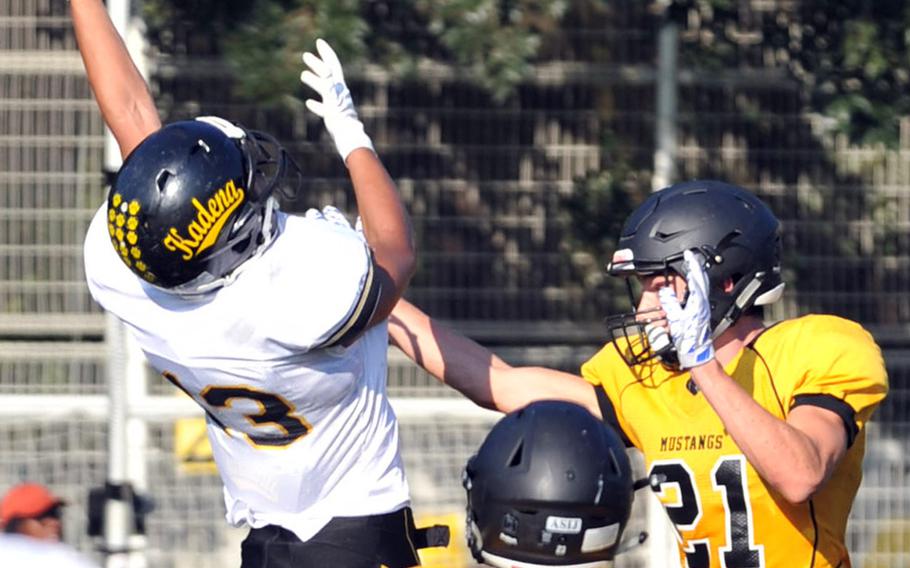 Kadena wide receiver Donte Savoy leaps above American School In Japan defenders Mike Taylor and Coe Laughlin.