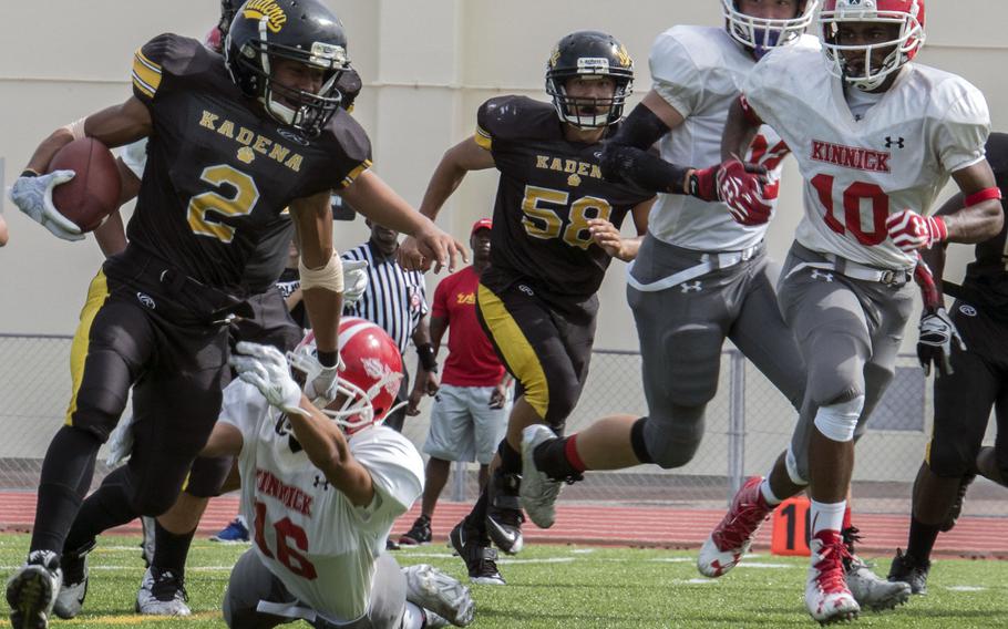 Kadena running back Jericho Williams dashes around right end ahead of Nile C. Kinnick defenders Andrew Urette, Devoney Stanley and Josh Brotherton.