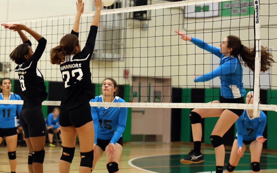 Osan's Haille Nugent tries to spike through the block of Daegu's Taylor Williams and Neena Ibit during Friday's girls volleyball match. The Cougars beat the Warriors in straight sets.